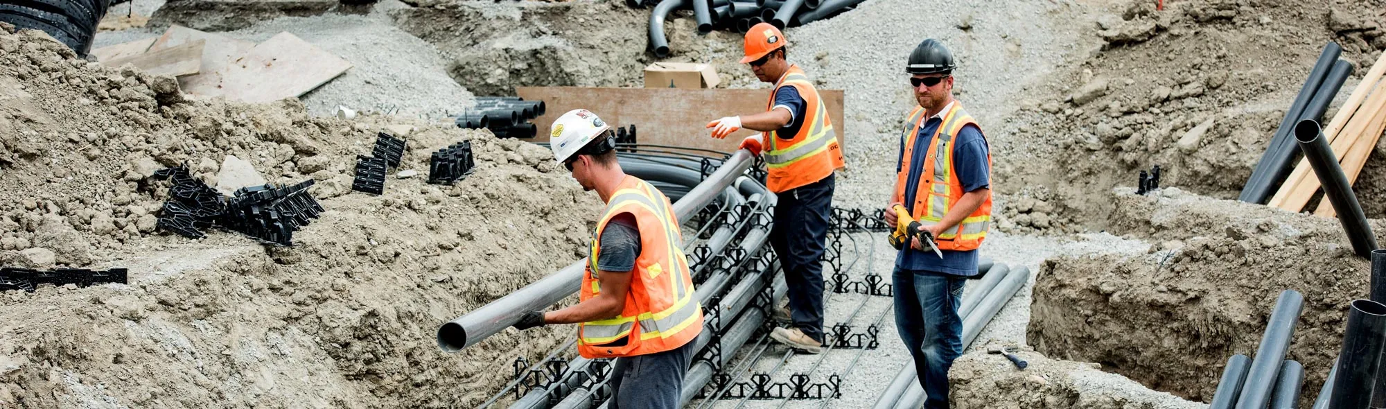 Construction workers handling pipes